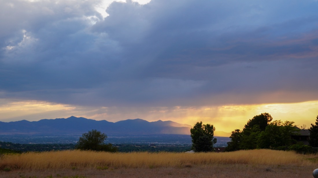Storm clouds breaking into golden light over a valley
